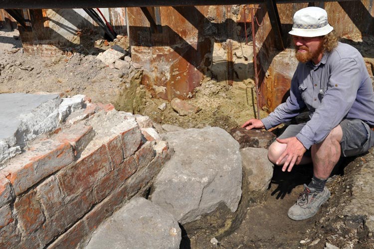 Archäologe Thies Evers zeigt das Fundament eines Turmes, das aus Eichenhölzern, Findlingen und Ziegeln besteht.