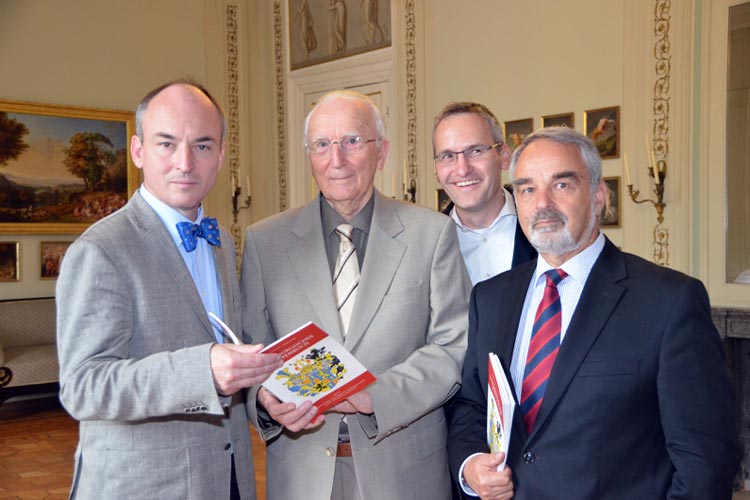 Die Autoren Dr. Jörgen Welp, Manfred Furchert, Verleger Florian Isensee und Landschaftspräsident Thomas Kossendey (von links) stellten das Wappenbuch vor.