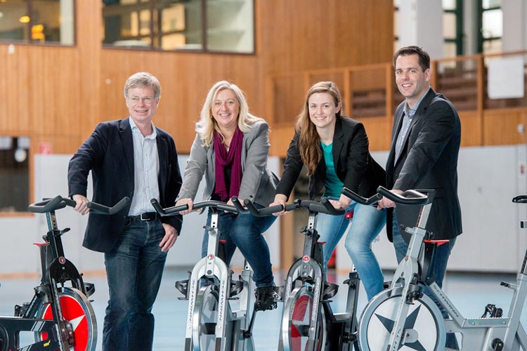 Christian Figge, Chefarzt für Allgemeine Psychiatrie und Psychotherapie, Monika Jüttner, Pflegedirektorin der Karl-Jaspers-Klinik, sowie die Sportwissenschaftler Sirka Ginsel und Mirko Brandes beim Indoor-Cycling.