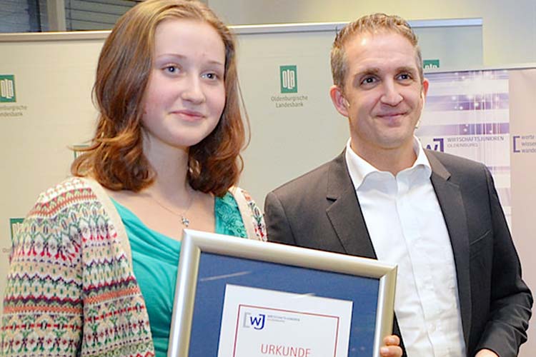 Paula Stöhr vom Neuen Gymnasium Oldenburg nahm stellvertretend für ihre Klasse 9d den Hauptpreis der Wirtschaftsjunioren, ein Besuch eines Heimspiels der EWE-Baskets, aus den Händen von Frank Glaubitz entgegen.