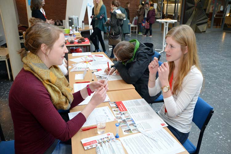 Franziska Behnen zeigt einer Studentin im Lichthof der Jade Hochschule Oldenburg, wie die Typisierung in Form einer Speichelprobe funktioniert.