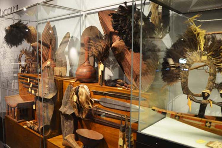 Vom Fliegenwedel über Kopfschmuck bis hin zu Dolchen und Speeren – so waren die Ausstellungsvitrinen um 1900 bestückt und vermittelten einen Furcht erregenden Eindruck.
