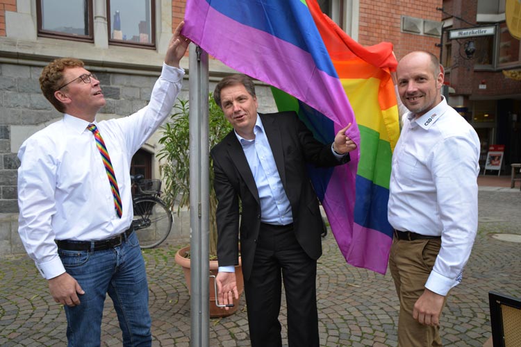 LuST-Vorsitzender Klemens Sieverding, Oberbürgermeister Jürgen Krogmann und LuST-Pressesprecher Kai Bölle hissen die Regenbogenfahne am Oldenburger Rathaus.