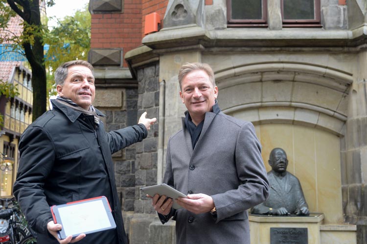 Jürgen Krogmann und Matthias Brückmann gehen vor dem Alten Oldenburger Rathaus mit den neuen WLAN-Hotspot online.