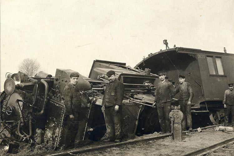 Eisenbahner vor einem entgleisten Zug, um 1900.