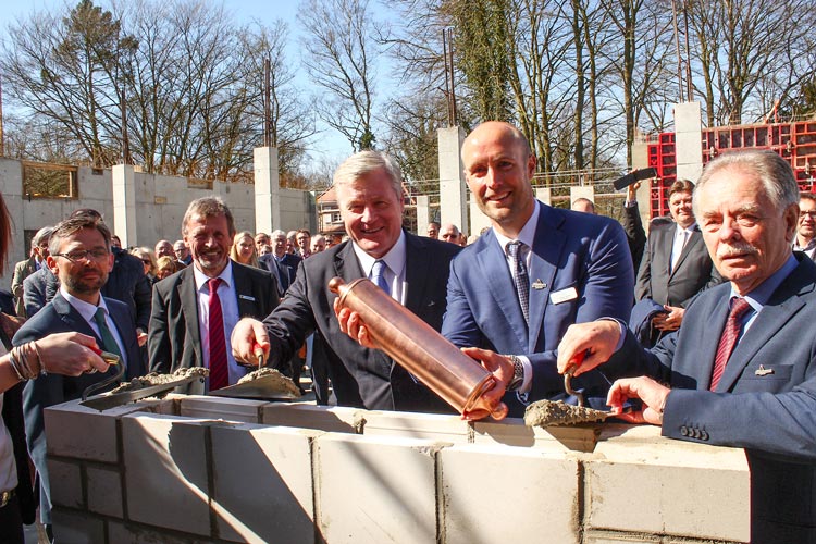 Jan Seeger, Mitglied des Vorstands der AOK Niedersachsen, Bürgermeister Dr. Arno Schilling, Dr. Bernd Althusmann, Minister für Wirtschaft, Arbeit, Verkehr und Digitalisierung, Geschäftsführer und Kurdirektor D. Norbert Hemken und Wolfgang Mickelat, Vorsitzender des Aufsichtsrates der Kurbetriebsgesellschaft, (von links) betonieren gemeinsam die Kupferrolle zur Grundsteinlegung ein.