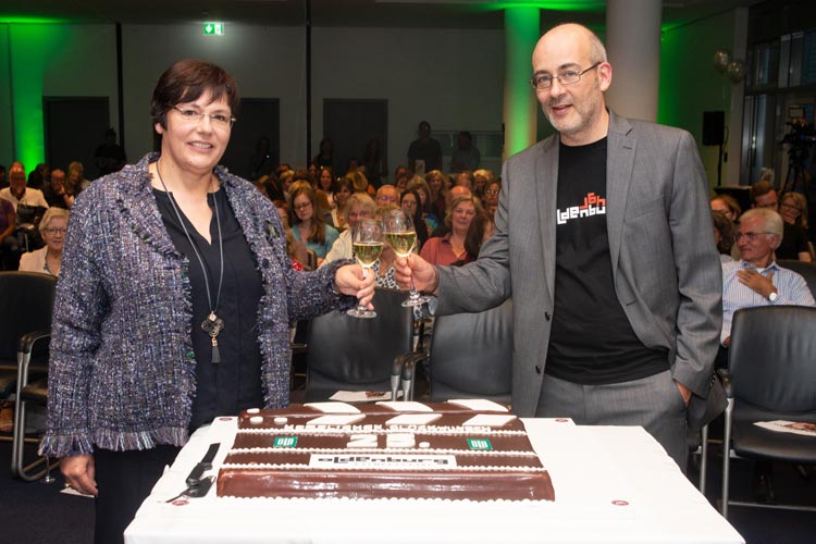 Karin Katerbau und Torsten Neumann vor der Jubiläumstorte im OLB-Saal.