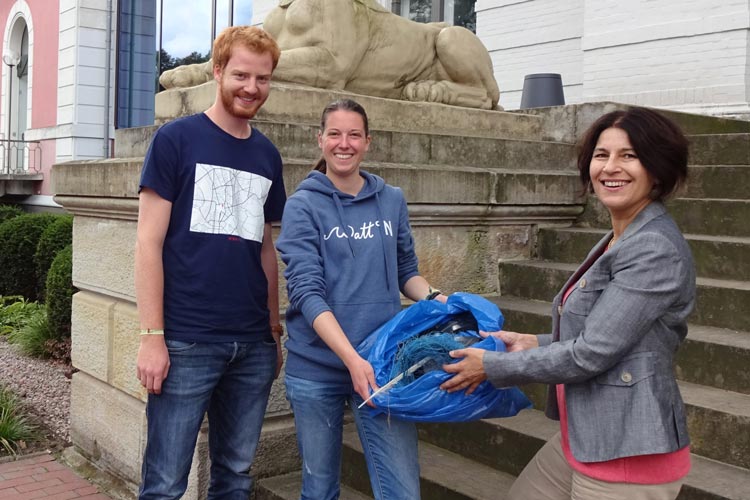 Jonathan Tosberg und Melanie Klock überreichen den gesammelten Meeresmüll an Museumsdirektorin Dr. Ursula Warnke.