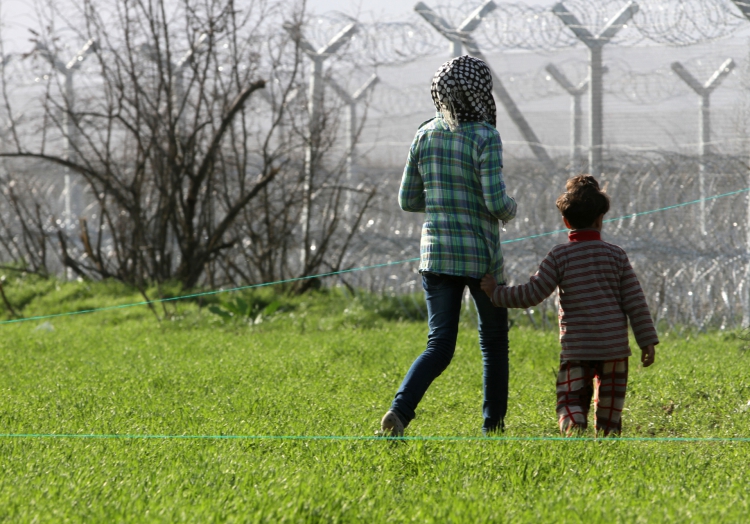 Flüchtlinge vor einem Grenzzaun, über dts Nachrichtenagentur