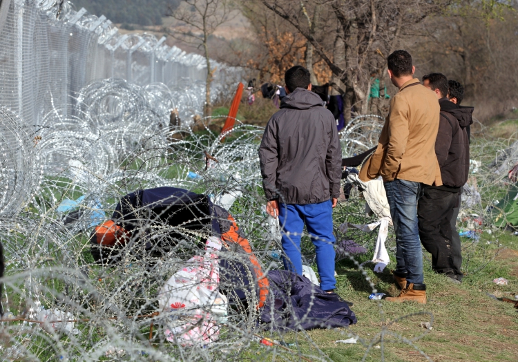 Flüchtlinge auf der Balkanroute vor einem Grenzzaun, über dts Nachrichtenagentur