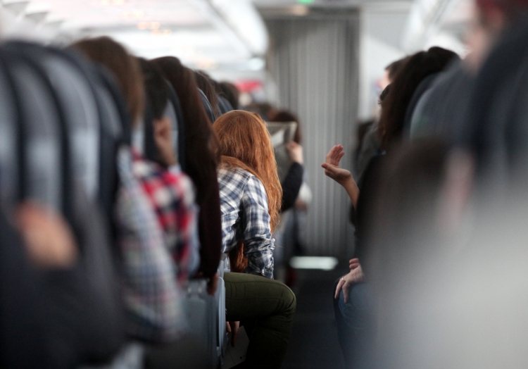 Rothaarige Frau in einem Flugzeug, über dts Nachrichtenagentur