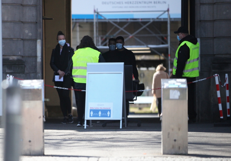 Menschen mit Mundschutz vor einem Krankenhaus, über dts Nachrichtenagentur