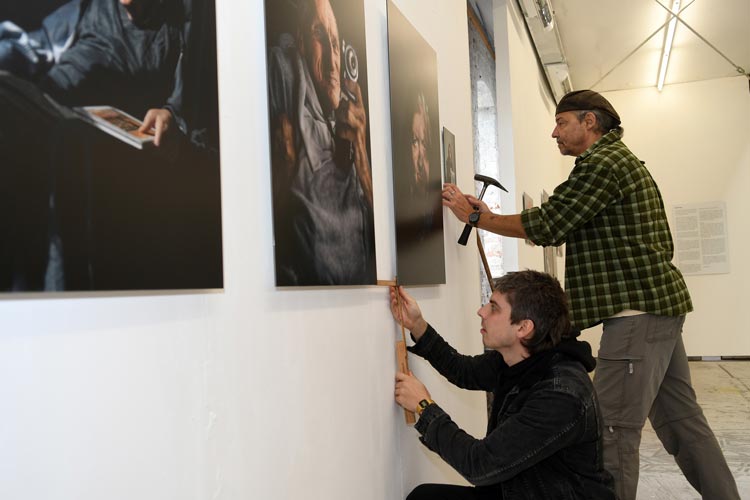 Fotograf Rafael Heygster (vorn) und Sven Tiedemann vom Verein „Haus der Fotografie“ arbeiten am Aufbau der Ausstellung „Würde wahren – Porträts ehemaliger Patient*innen der Psychiatrischen Langzeitklinik Kloster Blankenburg“ in der bau_werk Halle am Pferdemarkt.