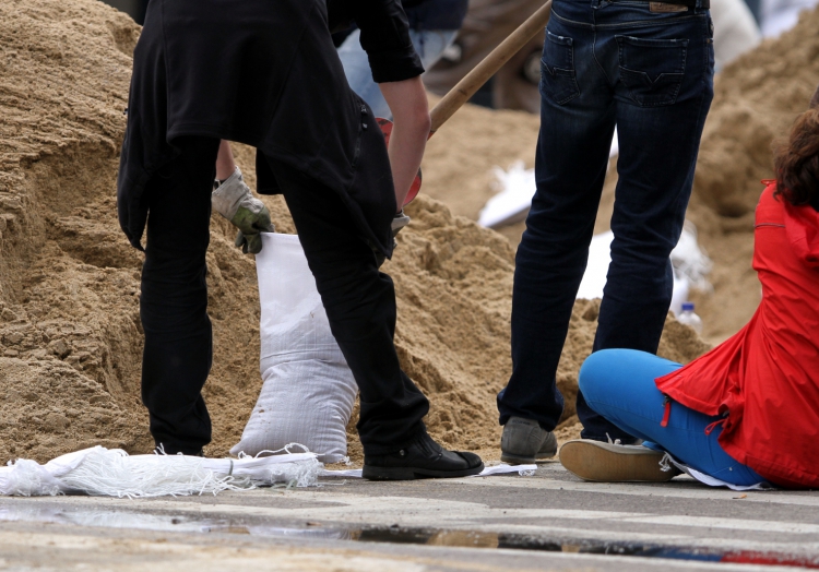 Hochwasser-Helfer beim Befüllen von Sandsäcken, über dts Nachrichtenagentur