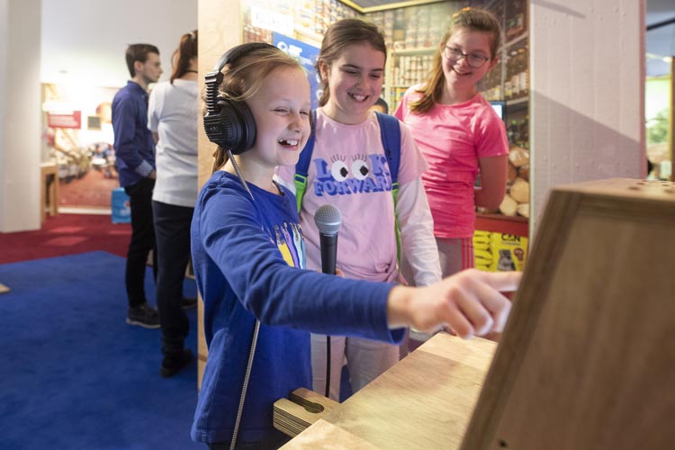 Kinder stehen an einer Mitmach-Station in der Ausstellung Mission 2030.