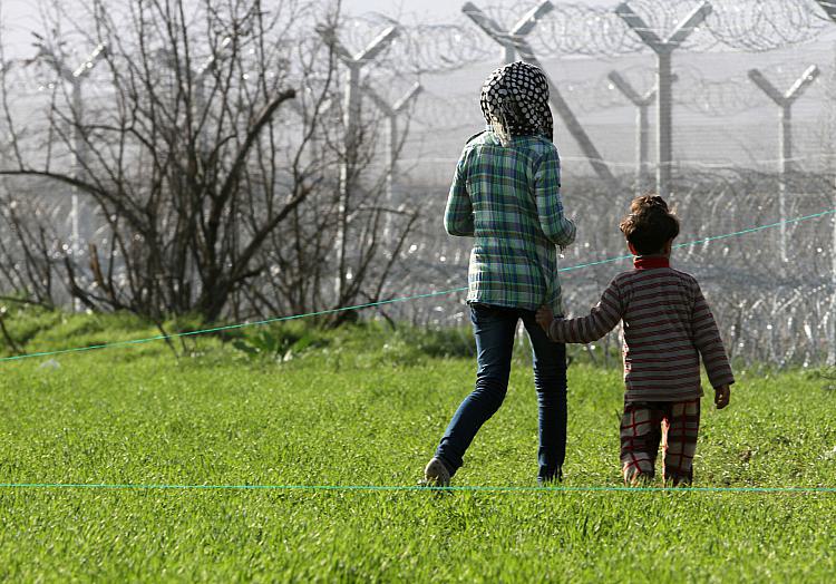 Flüchtlinge vor einem Grenzzaun, über dts Nachrichtenagentur