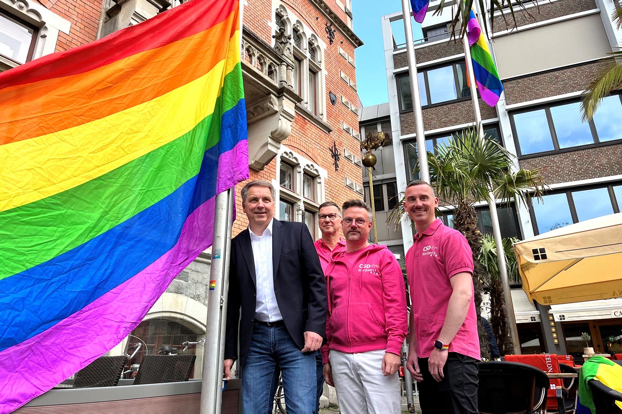 Oberbürgermeister Jürgen Krogmann (von links) hissen gemeinsam mit Thomas Sieverding, Achim Beyer und Andreas Gerbrand vom CSD Nordwest die Regenbogenflagge vorm Rathaus.