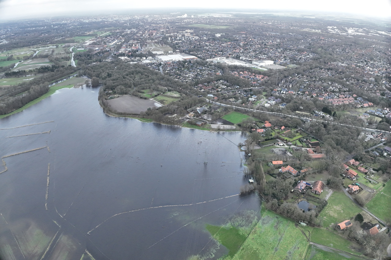 Die überflutete Freifläche hinter dem Friedhof in Bümmerstede, rechts im Bild ist der mobile Deich aus Hartschaumplatten als weiße Linie erkennbar.