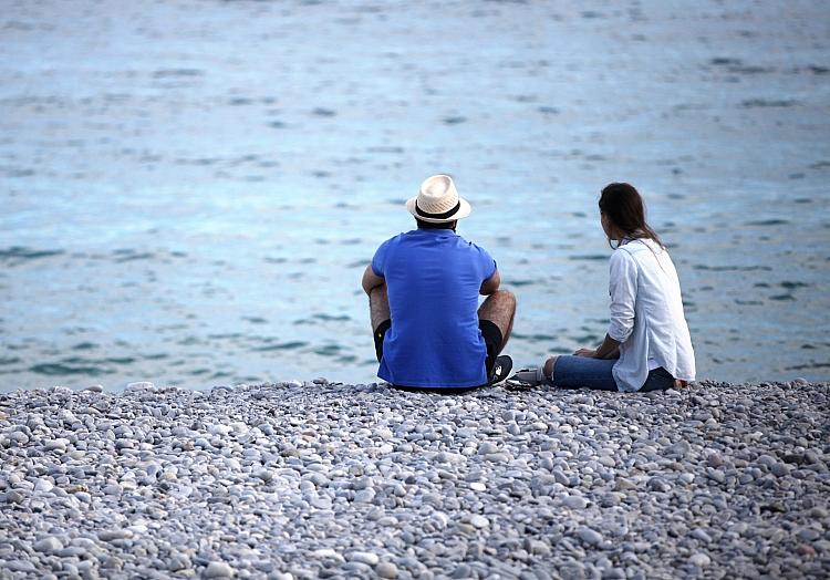 Mann und Frau sitzen am Strand, via dts Nachrichtenagentur