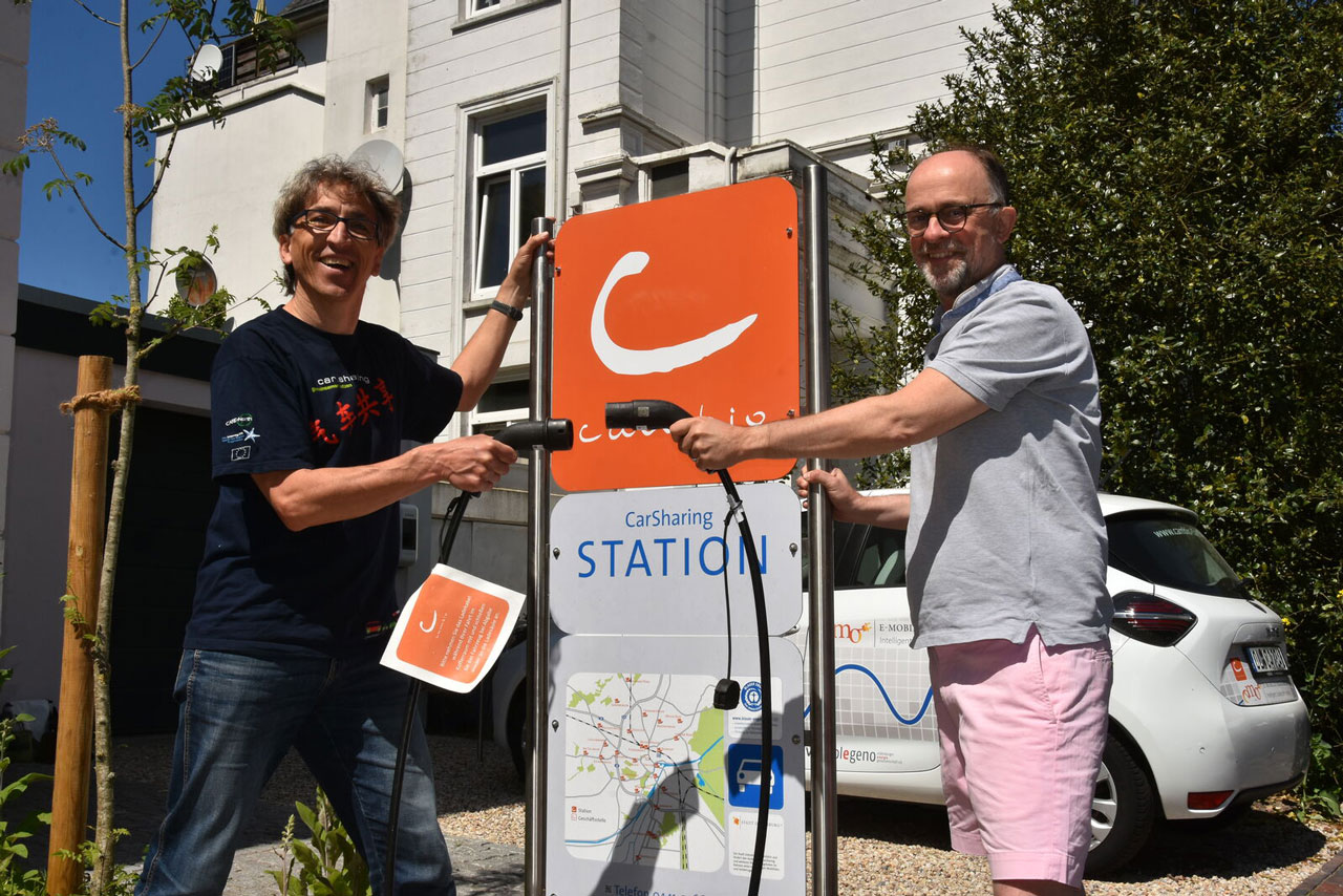 cambio-Chef Klaus Glöcker und Parkplatzeigentümer Gabriel Oliver Rohde (von links) am neuen Standort: erstmals auf privatem Grundstück mit eigener Ladestation.