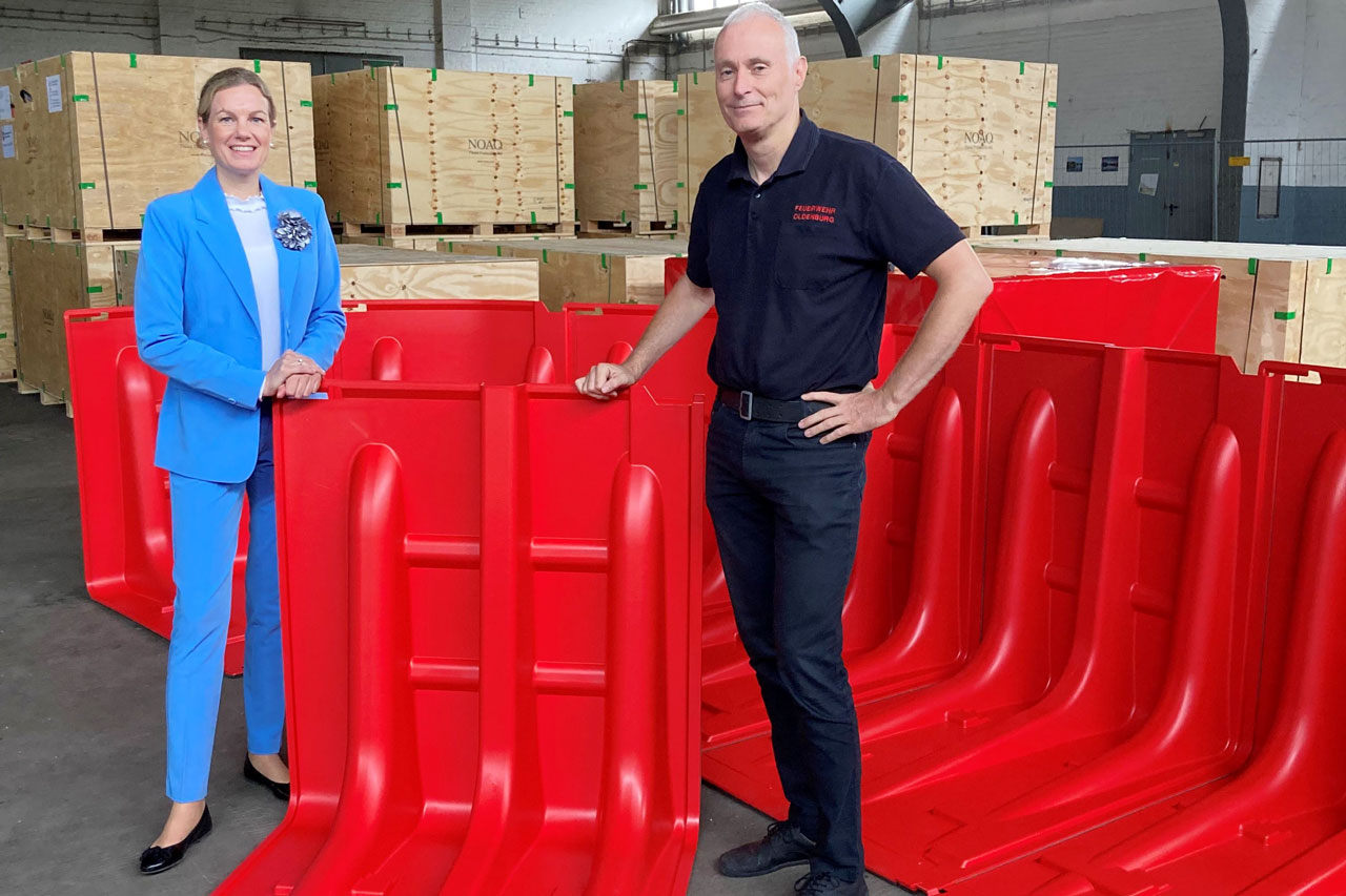 Erste Stadträtin Dr. Julia Figura und Feuerwehrchef Jens Spekker mit dem mobilen Hochwasserschutzsystem.