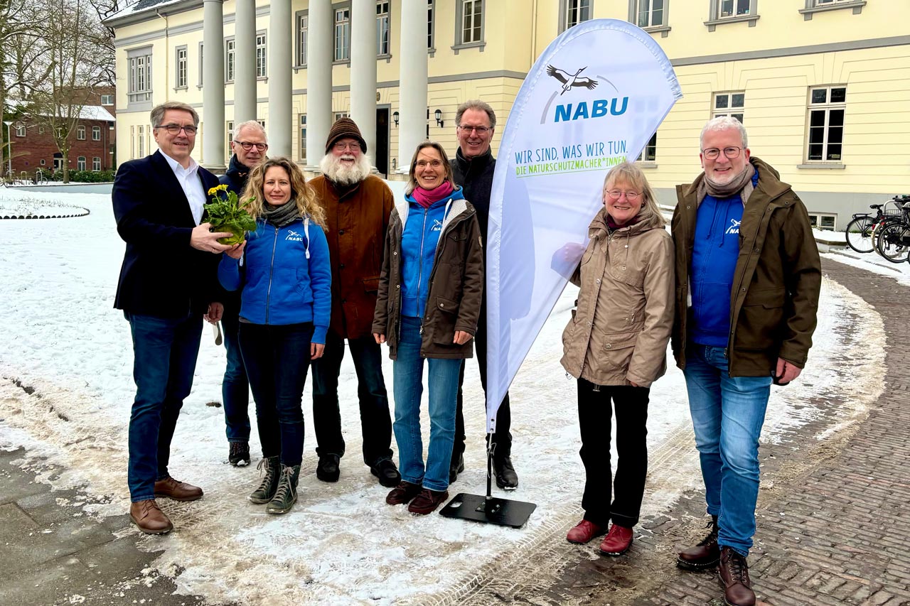 Oldenburgs Oberbürgermeister Jürgen Krogmann (links) überreicht Nicole Feige, Co-Leiterin der neuen Ökologischen NABU-Station Oldenburger Land (Önsol), symbolhaft eine Schlüsselblume. Carsten Heinecke (Önsol), Gisela Wicke (stellvertretende Vorsitzende NABU-Landesverband Niedersachsen e. V.), Ralf Becker (Untere Naturschutzbehörde), Elisabeth Woesner (Önsol), Thomas Günther (Vorstand Umwelthaus Oldenburg e. V.) und Robert Sprenger (Amtsleiter für Umweltschutz und Bauordnung) (von rechts) freuen sich über die neuen Räume.